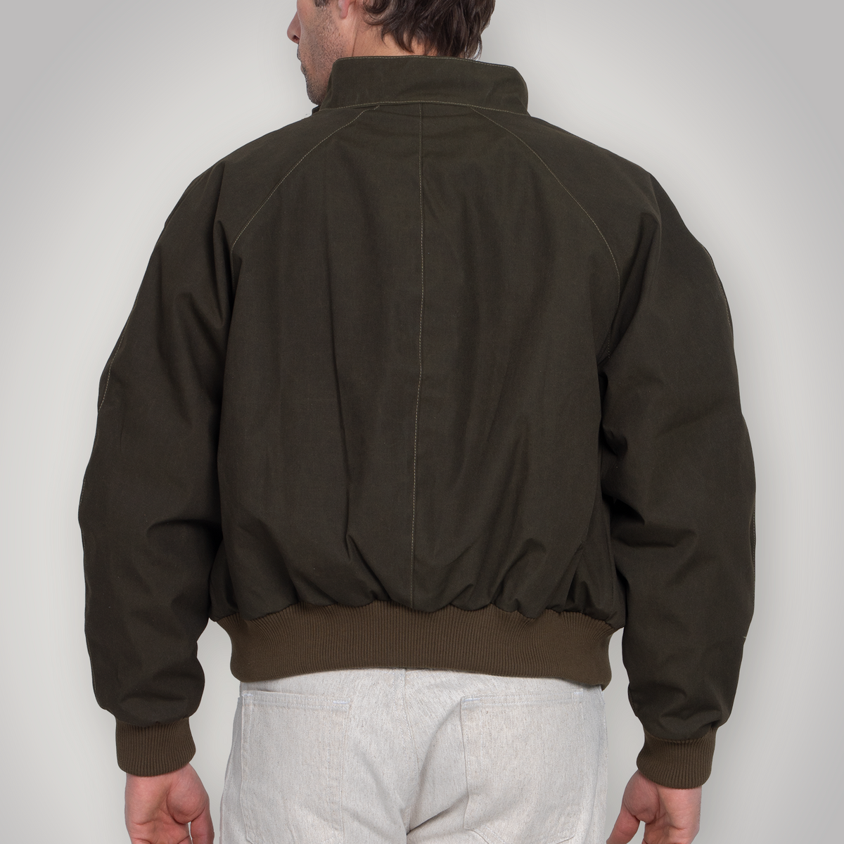 Side view of the olive Harrington jacket on the model.