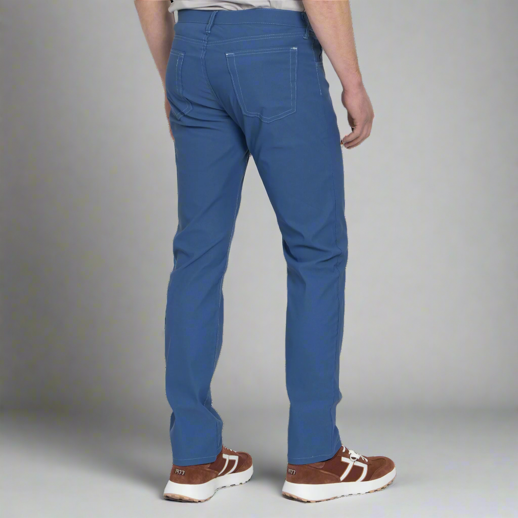 Detail of the front pocket, zipper fly and waistband button on the light blue technical jeans.