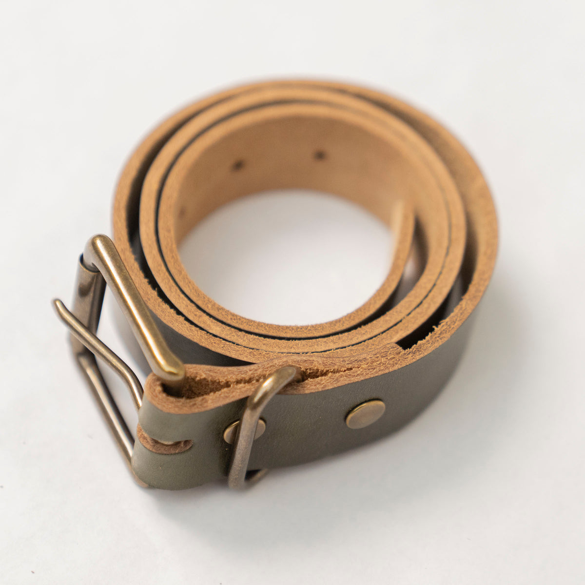 Back side of the olive leather belt showing the bull hide finish and stitching at the buckle.