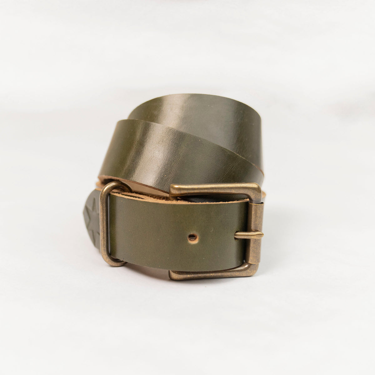Full length of the olive leather belt laid flat, 1 3/8" wide strap with punched holes.