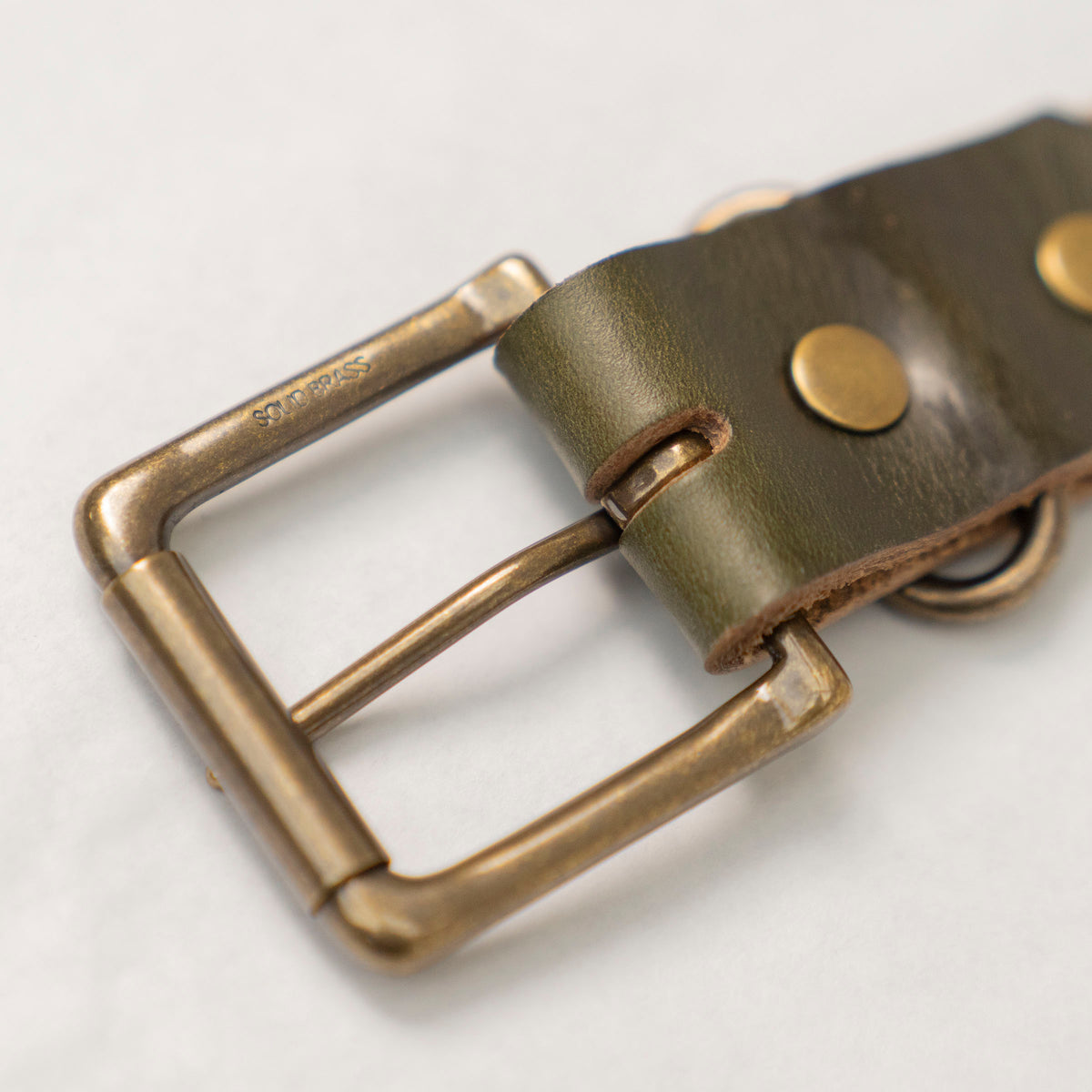 Olive leather belt worn through the belt loops of Dearborn Denim jeans.