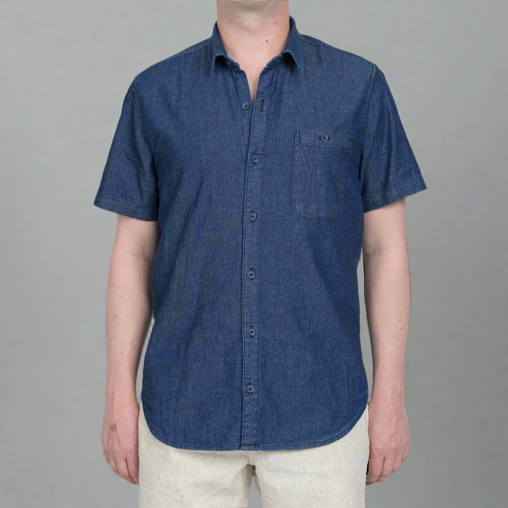 Short sleeve chambray button down shirt in light blue, laid flat and buttoned.