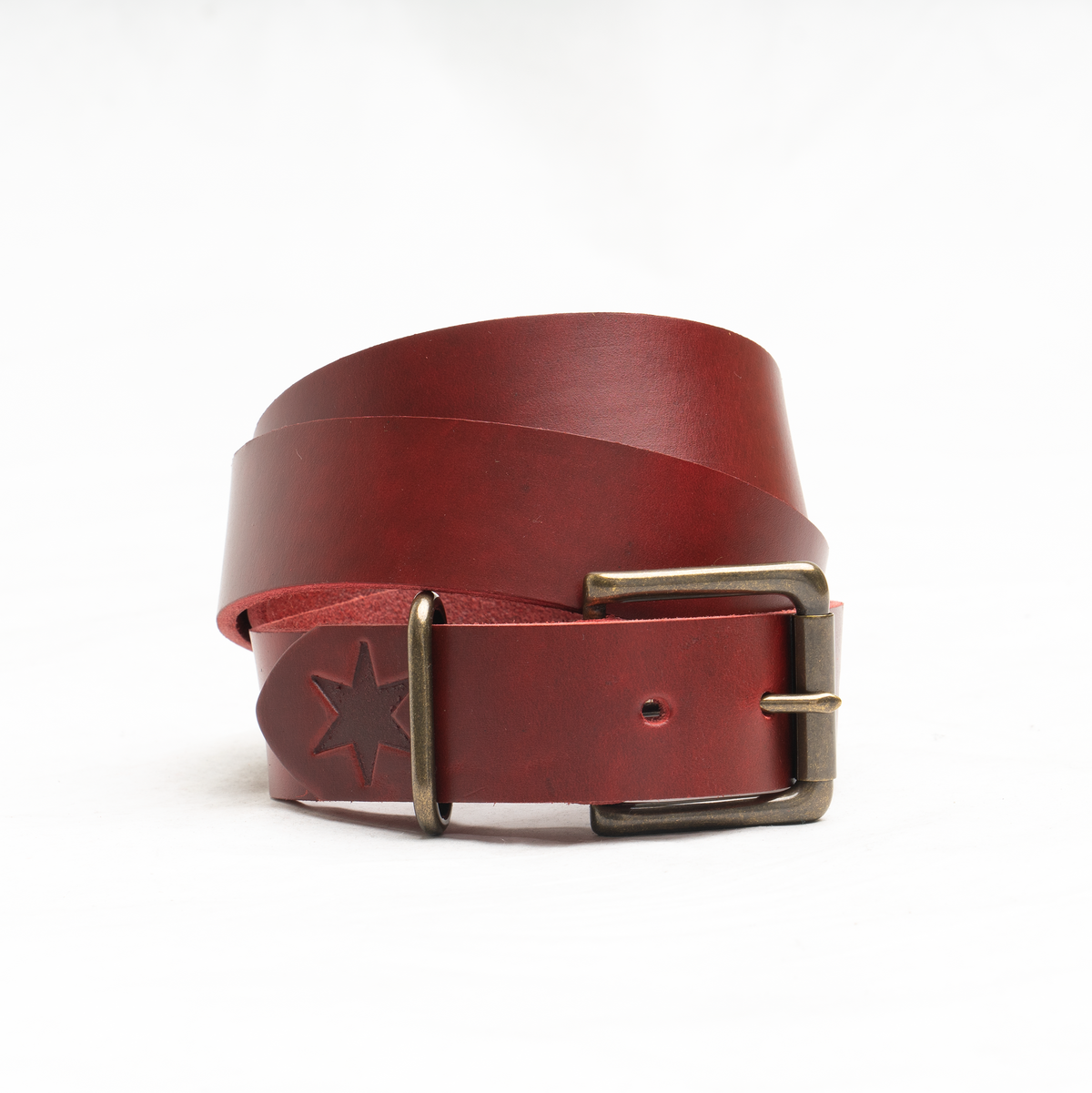Close-up of the solid brass buckle and antique brass finish on the red leather belt