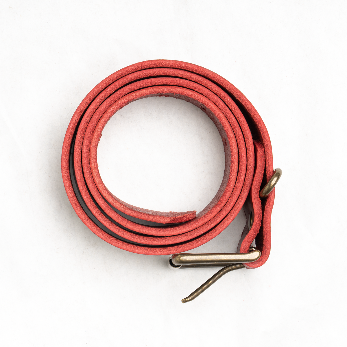 Detail of the red bull hide strap showing leather grain and belt holes