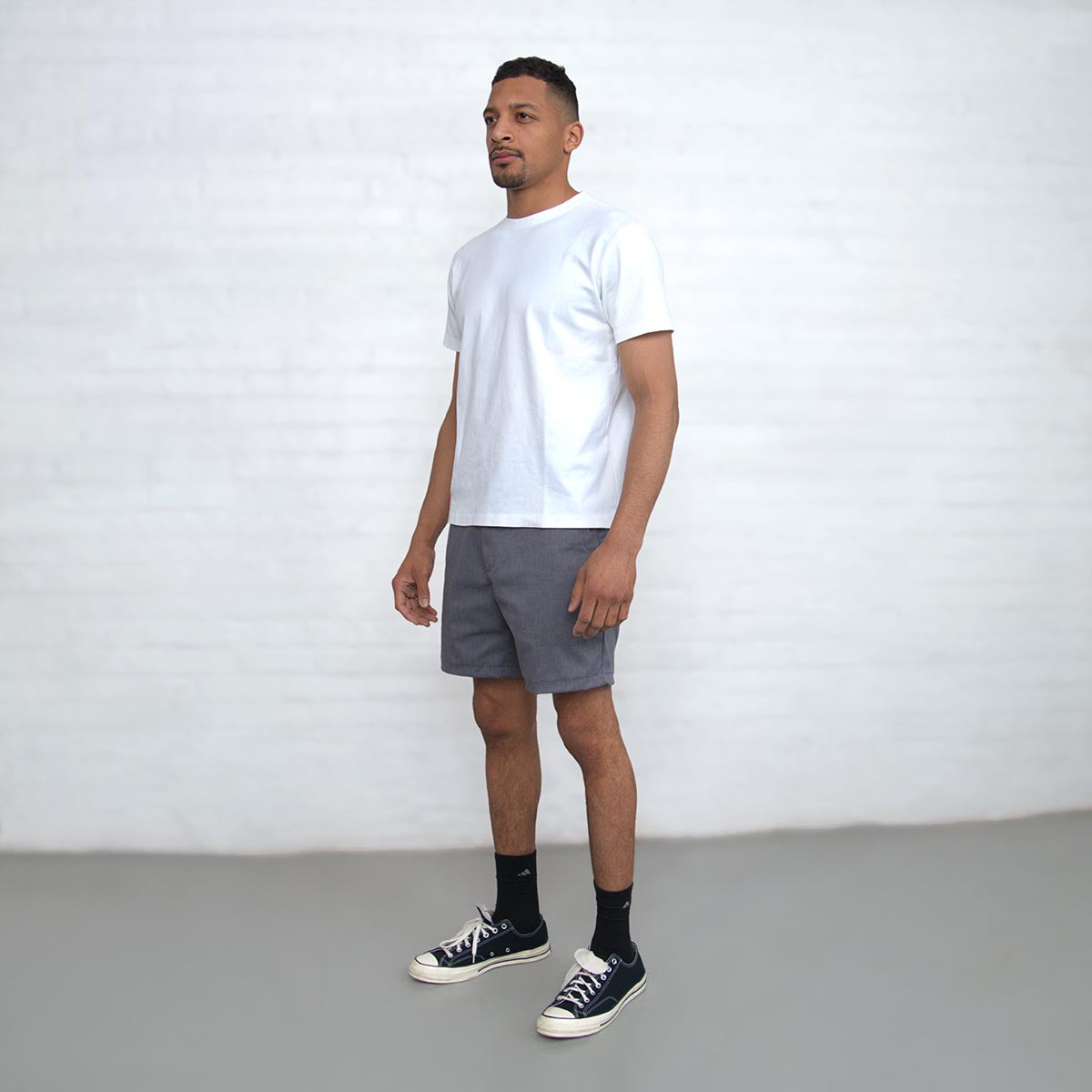 Close-up of the branded Italian button and YKK zipper fly on grey chino shorts