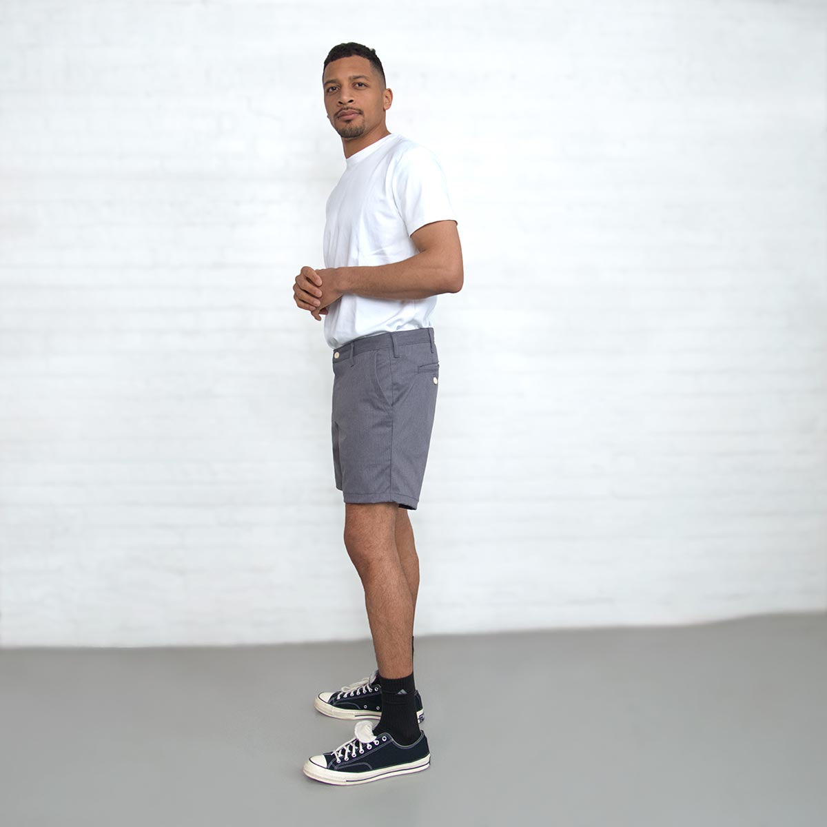 Man wearing grey chino shorts, back view showing rear welt pockets