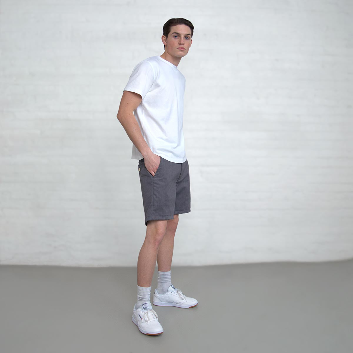 Back view of grey chino shorts showing button closure welt pockets