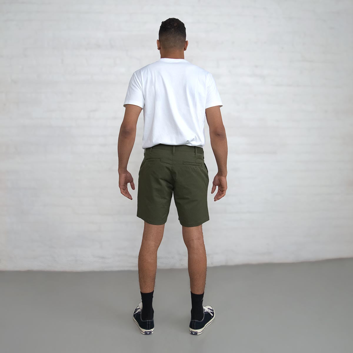 Close-up of the branded Italian button and YKK America zipper on olive chino shorts.