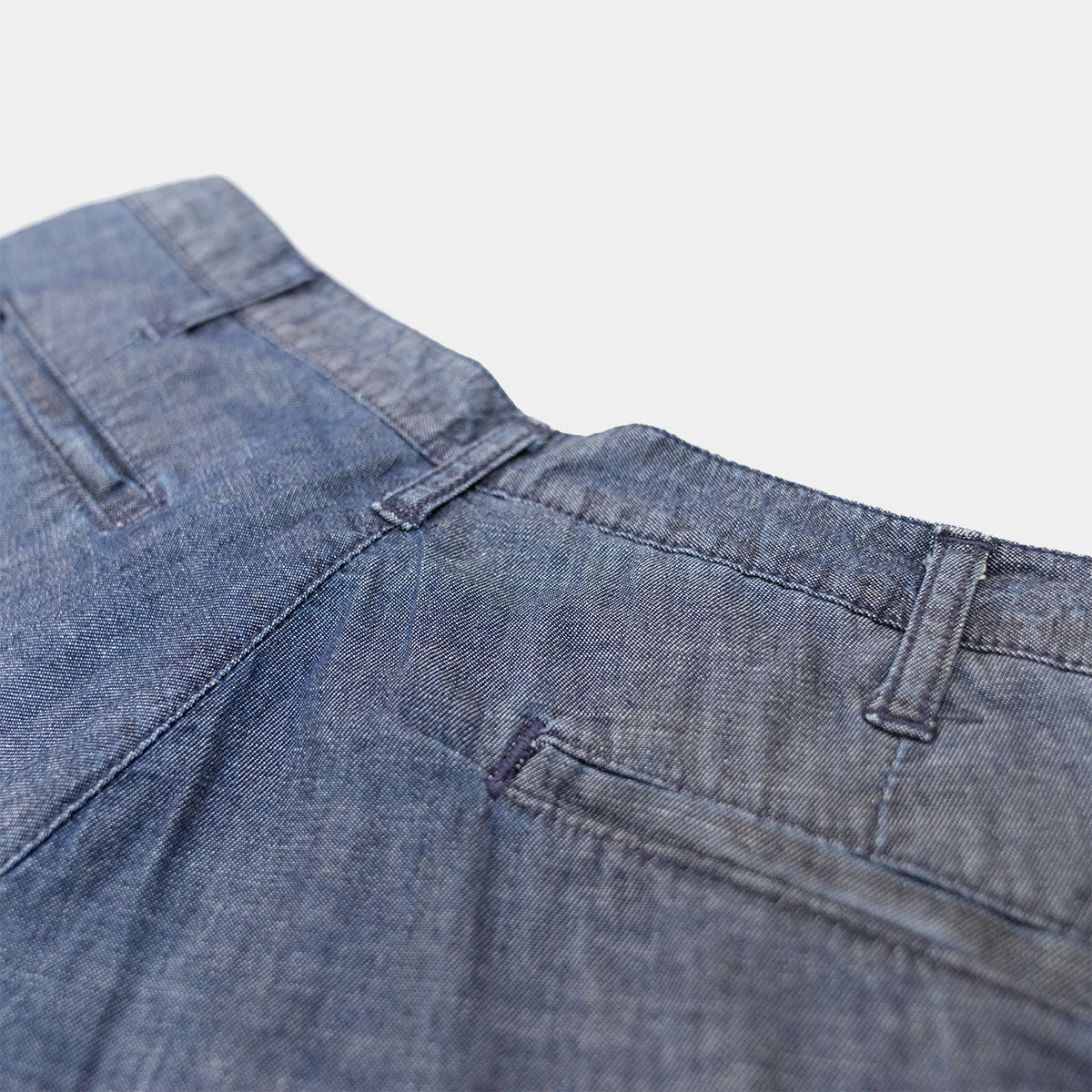Side view of chambray shorts worn with a belt and untucked shirt