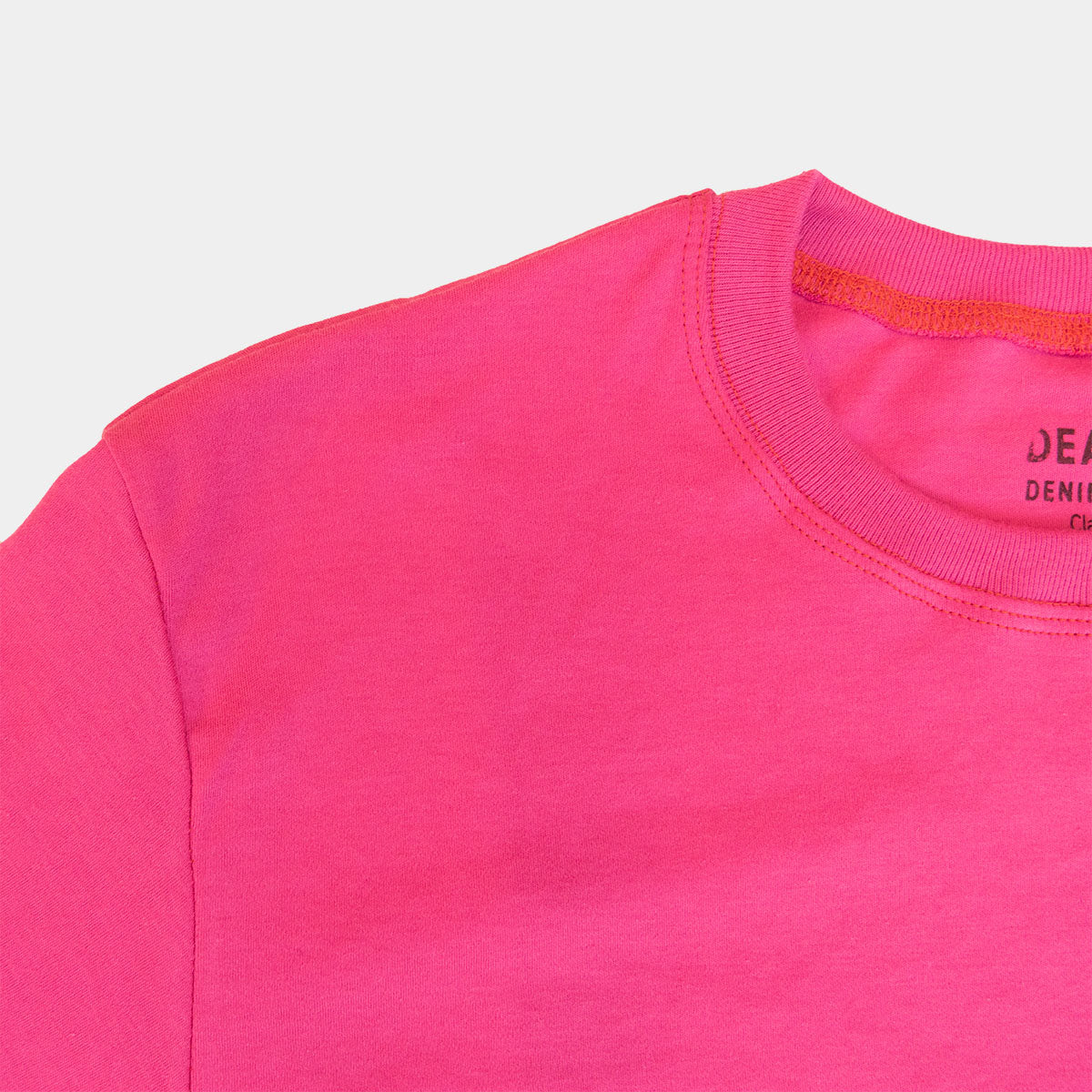 Close-up of the chest pocket on the magenta t-shirt