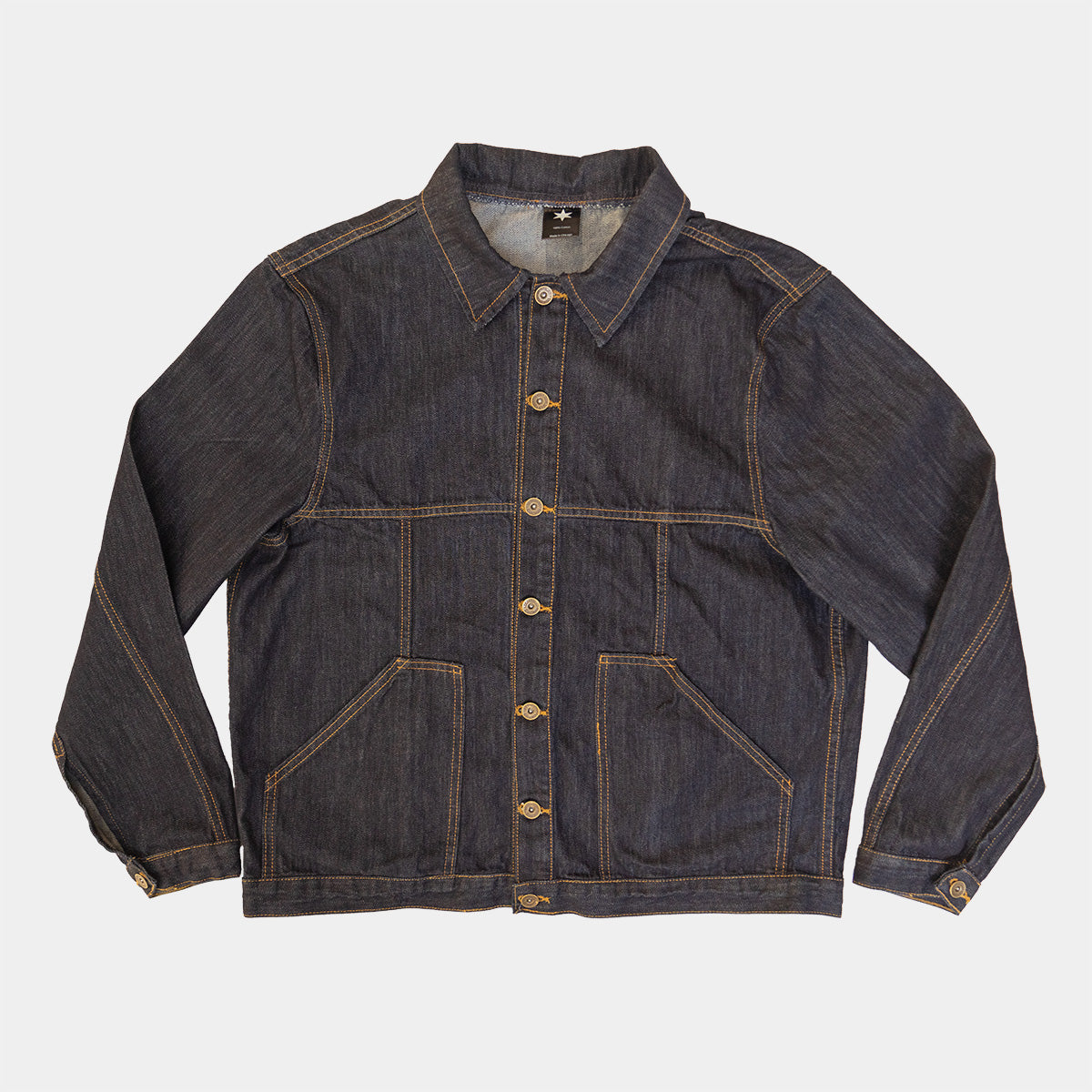 Dark wash denim jacket laid flat on a light background
