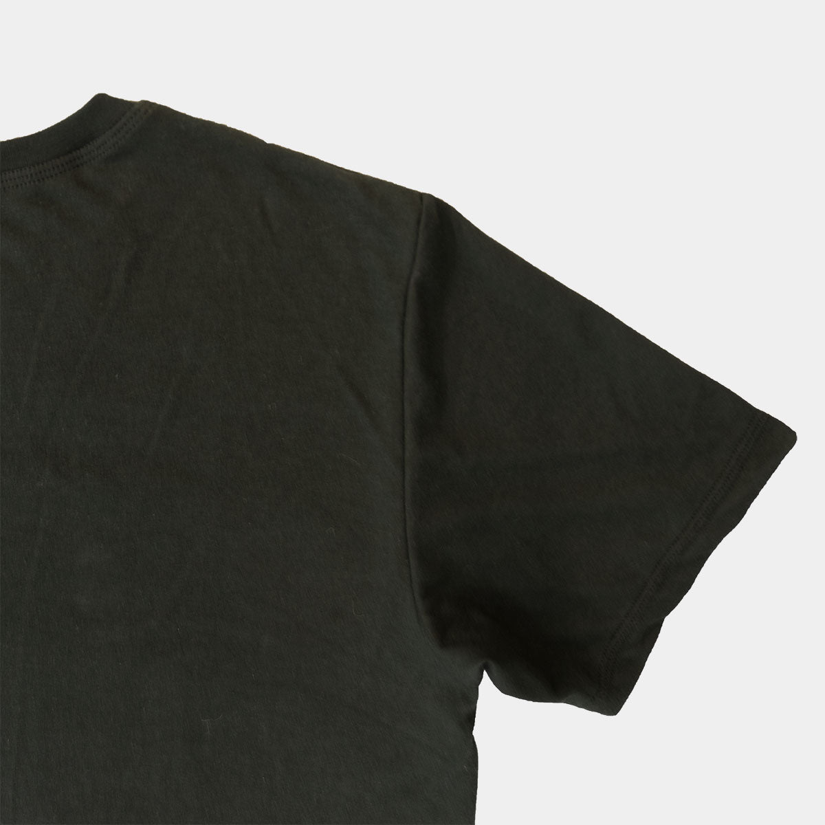 Detail of the short sleeve hem and side seam on the black Supima cotton tee.