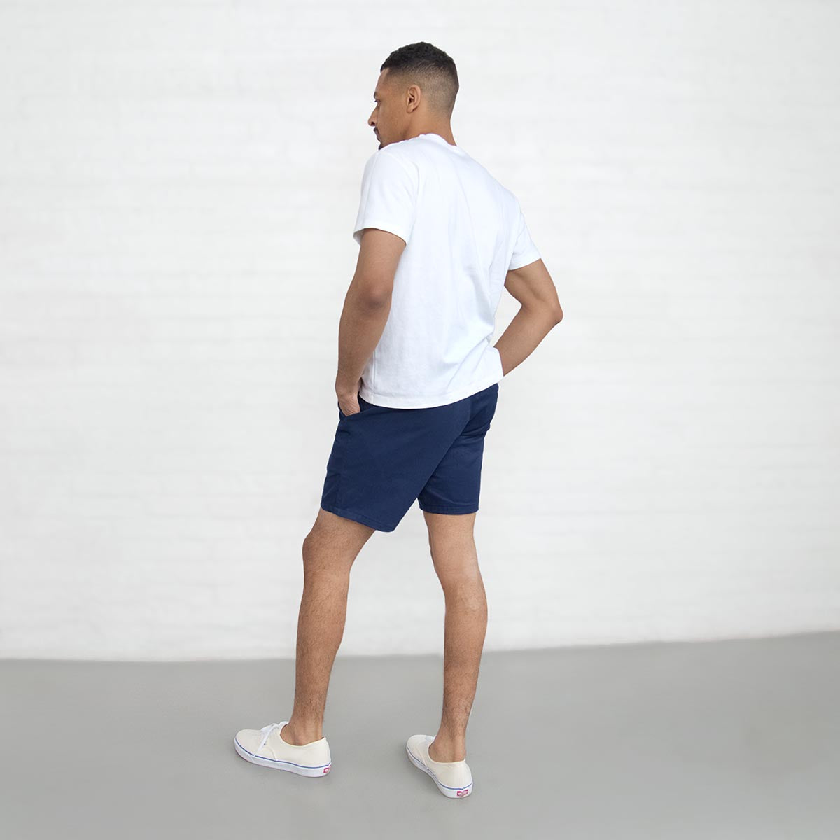 Model wearing navy chino shorts, side view showing the fit through the thigh.
