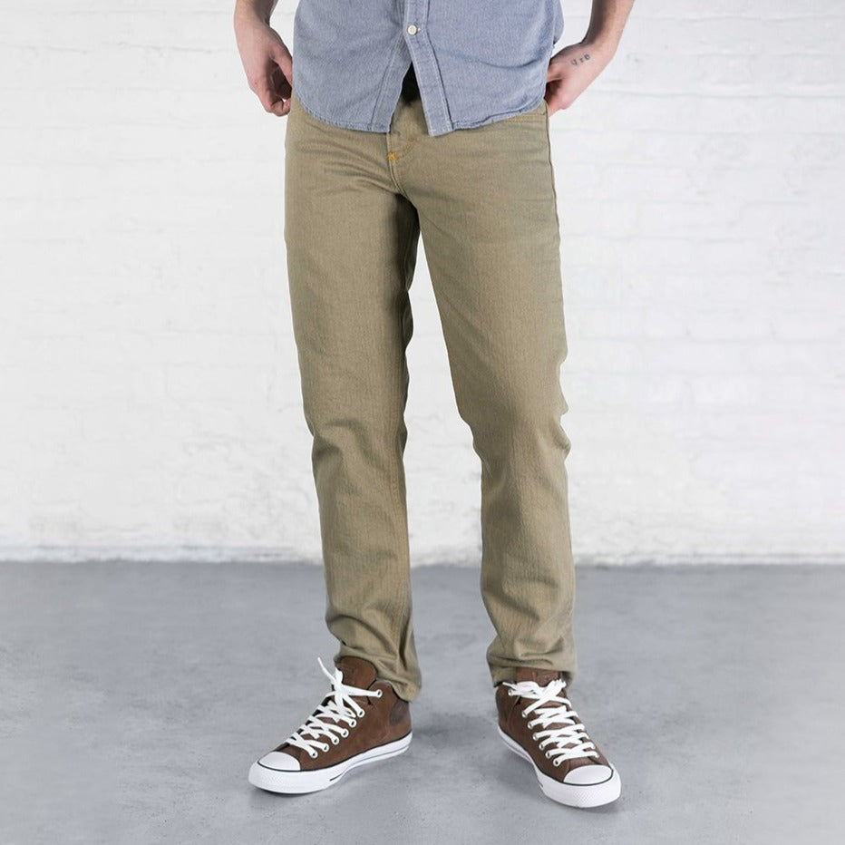 Slim fit khaki stretch jeans shown from the front with tapered leg, leather patch and gold leaf button.