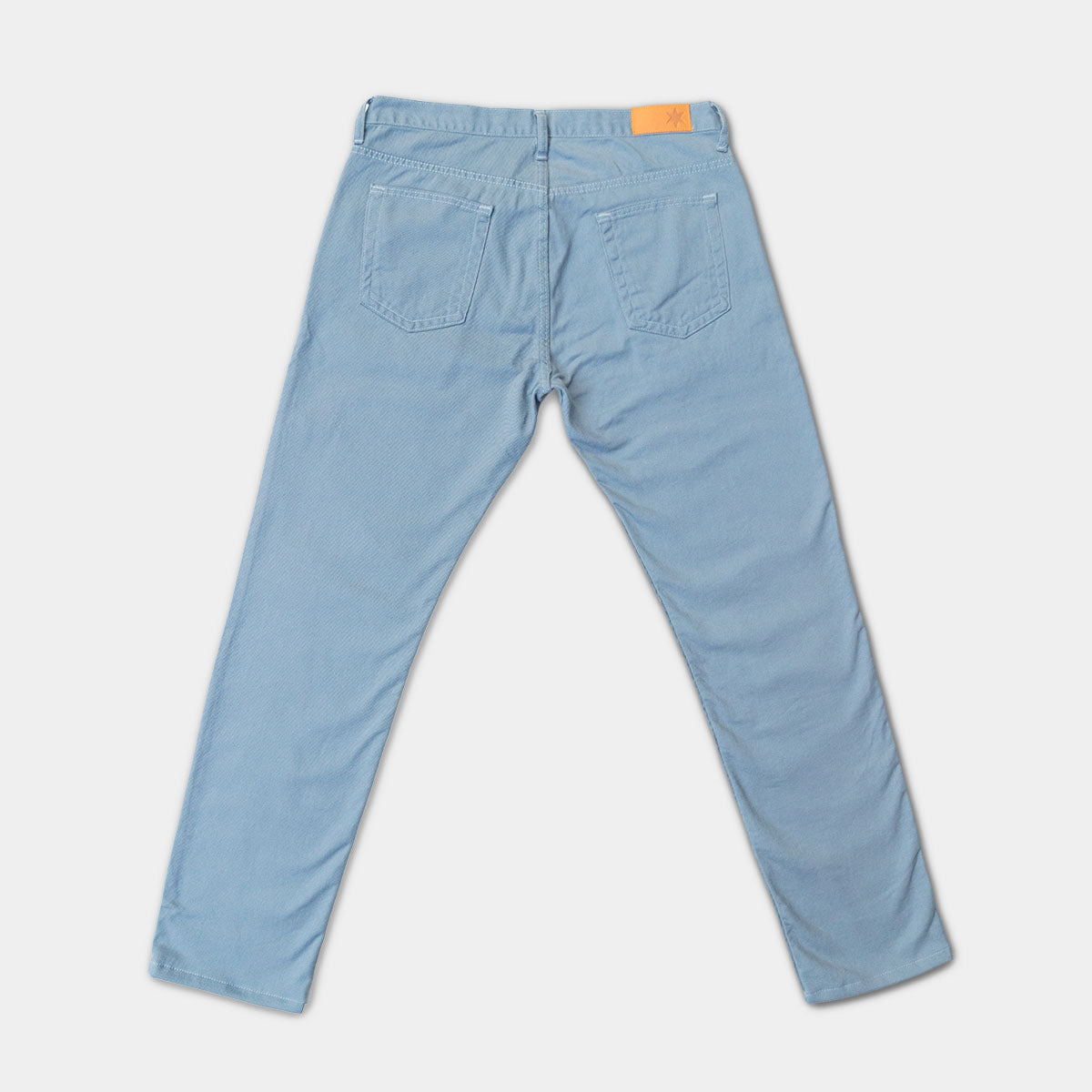Back view of slate tailored fit jeans showing back pockets and Horween leather patch at the waistband.