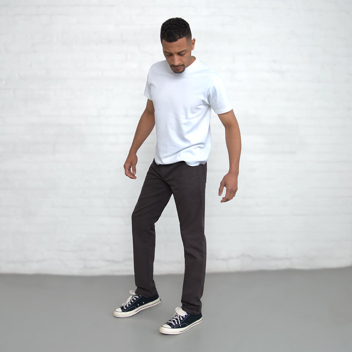 Man wearing espresso Tailored Fit jeans, full-length front view.