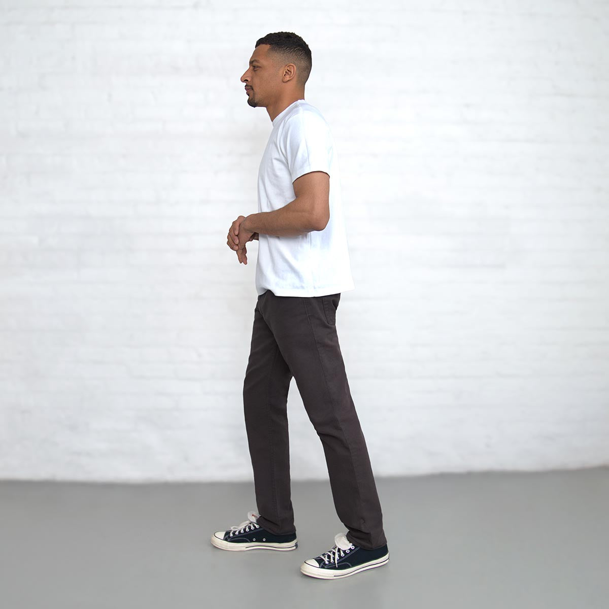 Man wearing espresso Tailored Fit jeans, full-length back view.