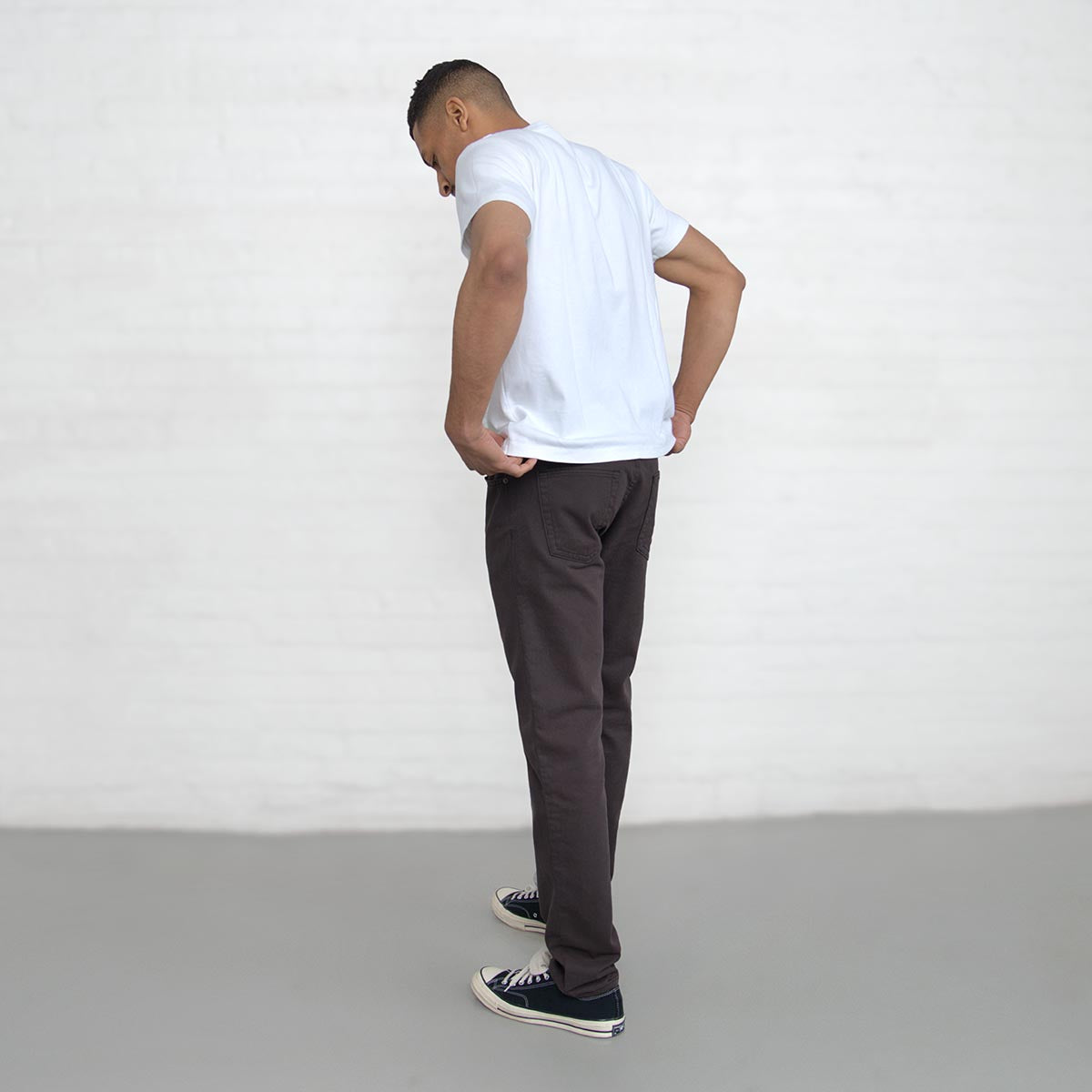 Side view of the espresso jeans showing the medium rise and taper below the knee.