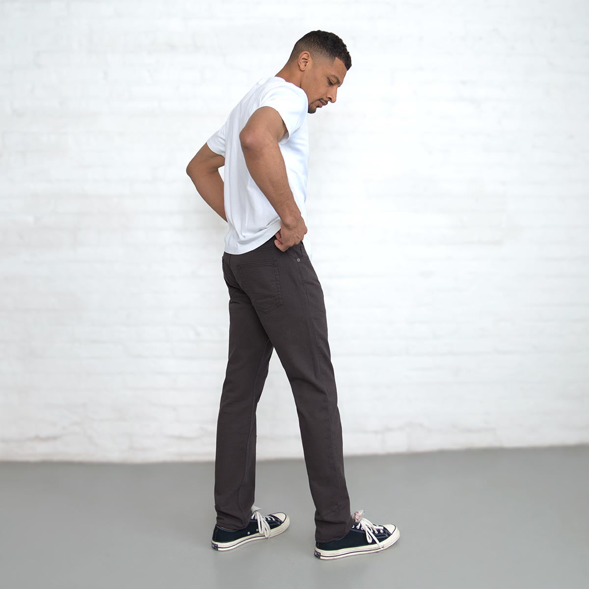 Man wearing espresso Tailored Fit jeans, side profile showing leg taper.
