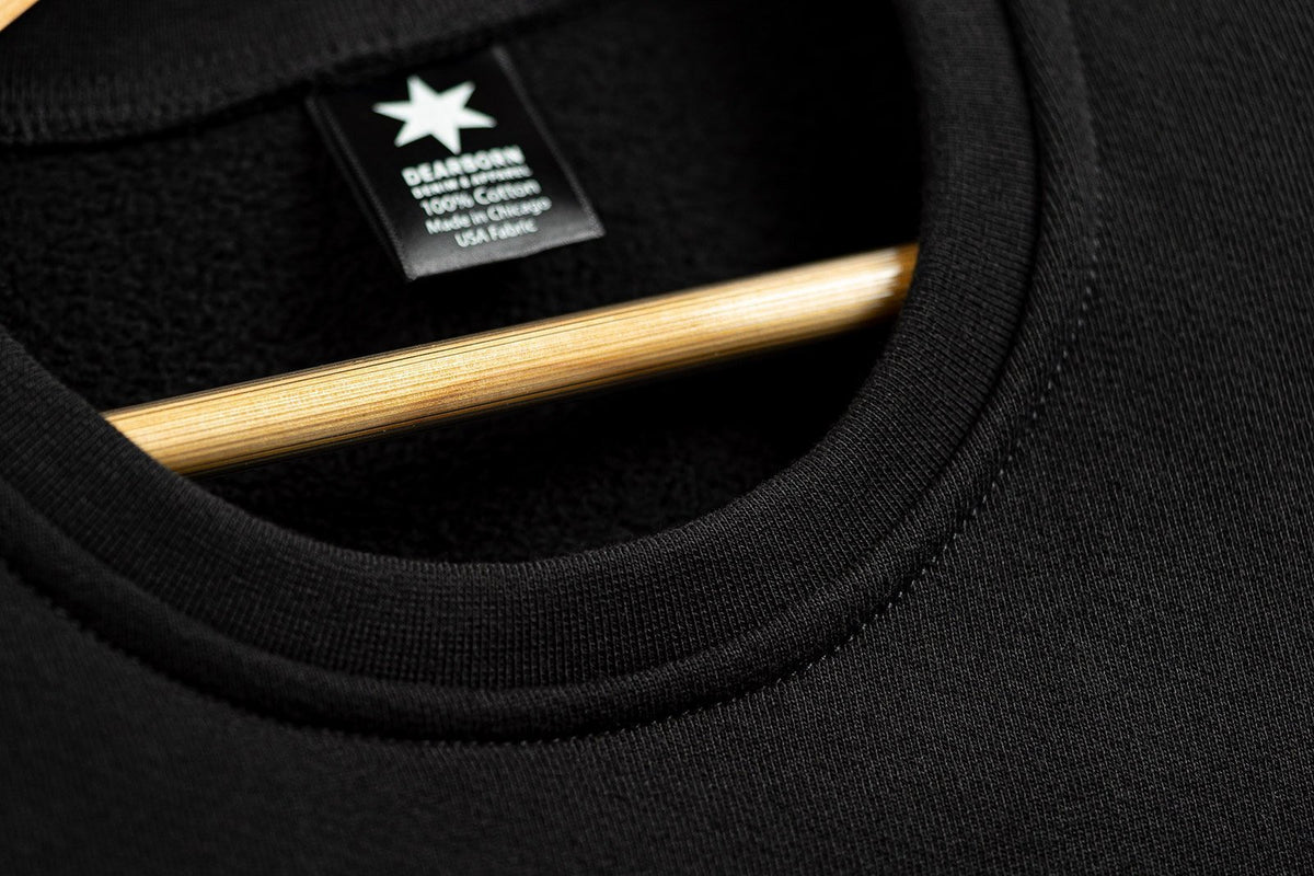 Close-up of the gathered cuff and ribbing on the black sweatshirt