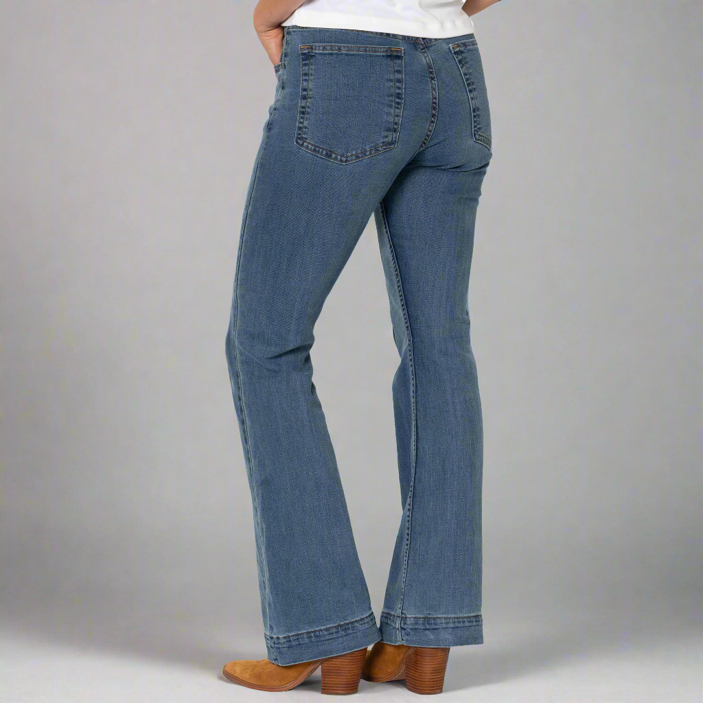 Close-up of the front patch pockets, button closure and zip-fly on the light wash denim.