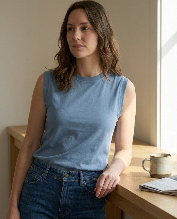 Blue sleeveless combed cotton top shown from the front with a fitted collar and framed shoulder.