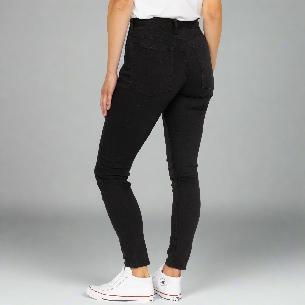 Detail of the front pocket and stitching on black high rise skinny jeans.