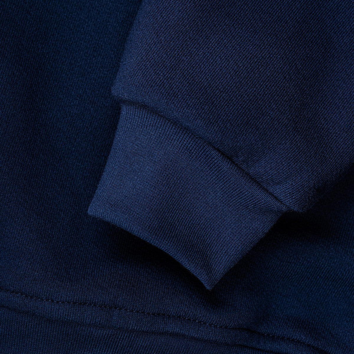 Detail of the gathered cuff and waist on the navy sweatshirt.