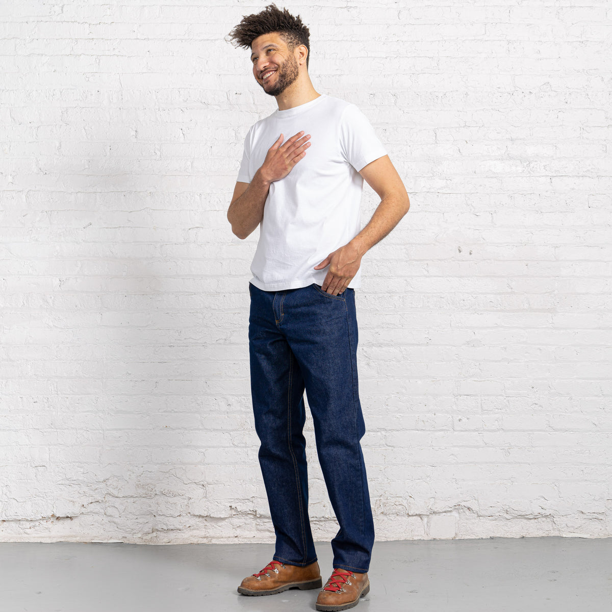 Back view of dark wash relaxed fit jeans showing back pockets and Horween leather patch at the waistband.