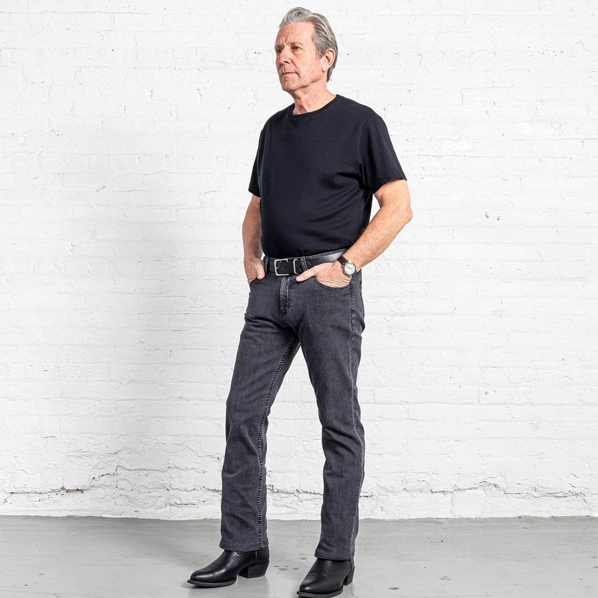 Side view of grey wash boot cut jeans showing taper below the knee