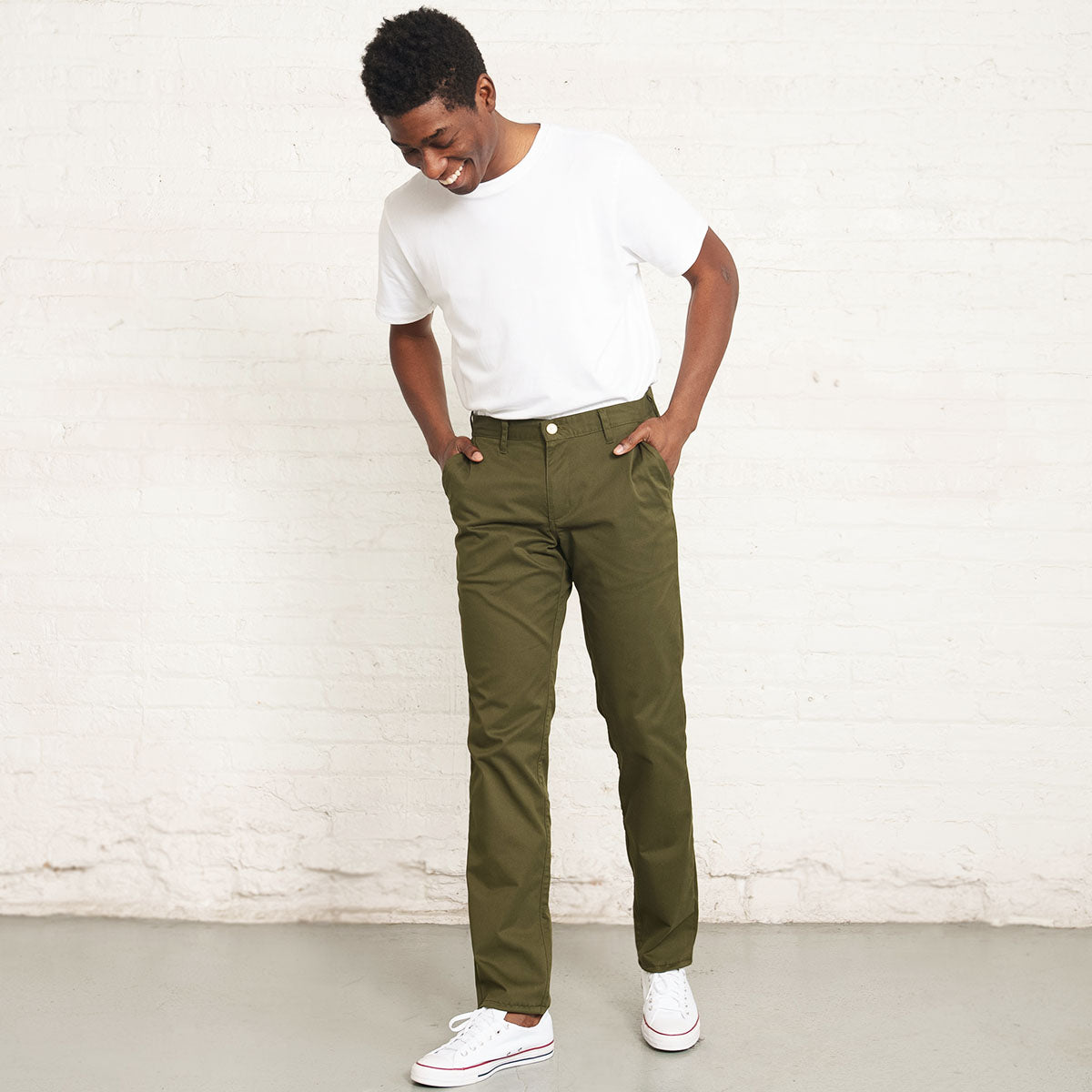 Close-up of the branded Italian button and YKK zipper fly on olive chinos