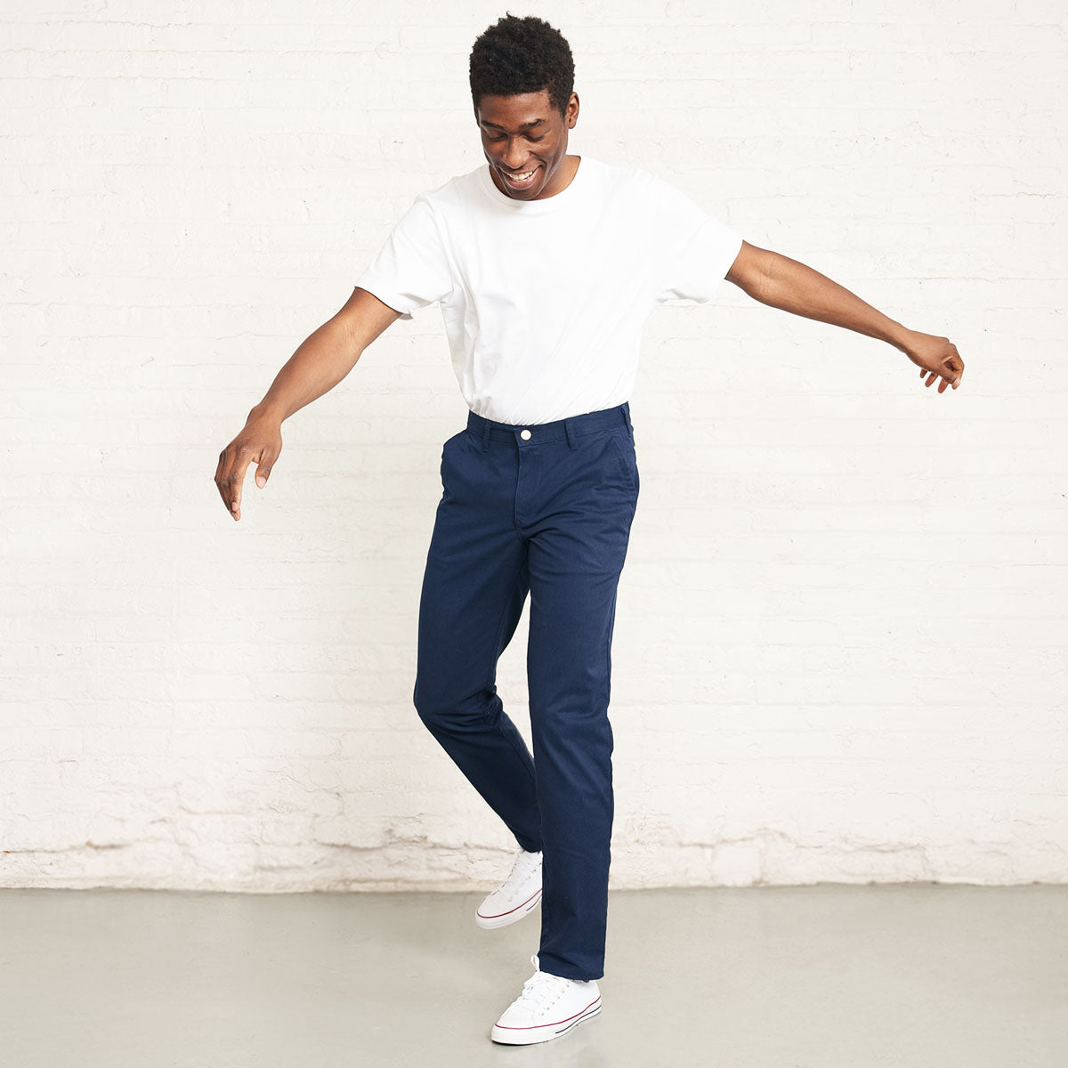 Man wearing the navy stretch chino, side view showing the tapered leg.