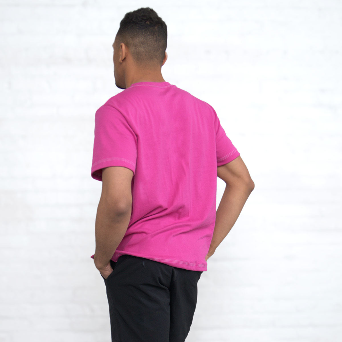 Detail of the notched sweep at the hem of the magenta t-shirt