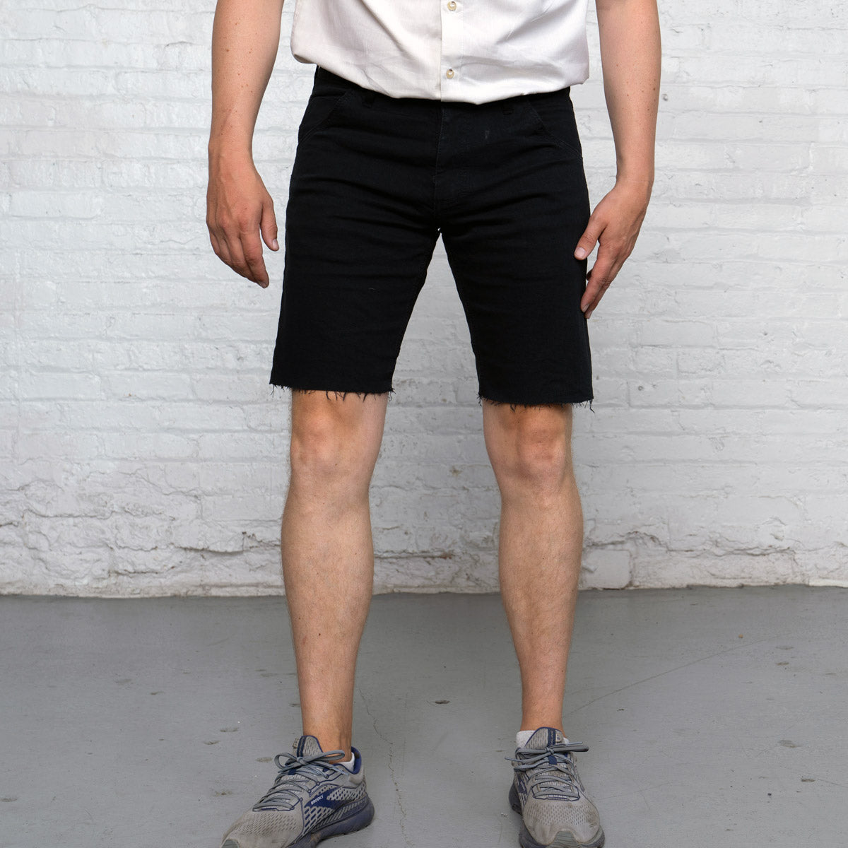 Black commuter shorts shown flat from the front with raw edge hem and 7-inch inseam.