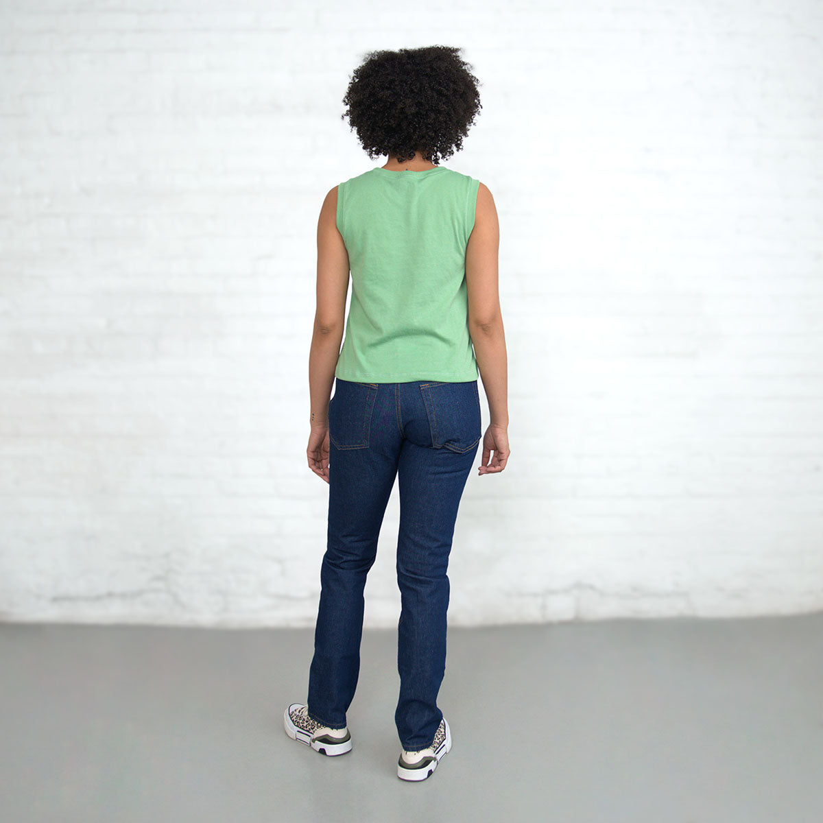 Jade sleeveless crop tank worn with jeans, back view