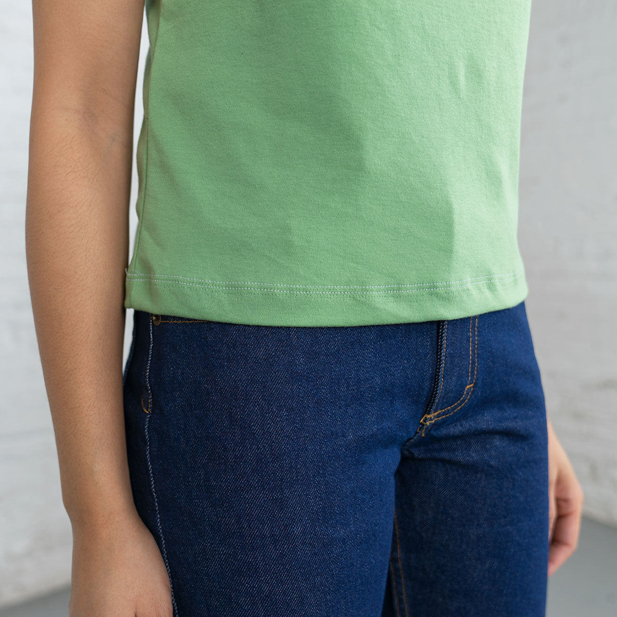 Model wearing the jade Supima crop tank, three-quarter view