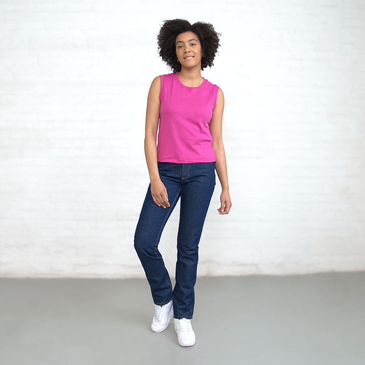 Magenta sleeveless crop top worn with jeans, front view