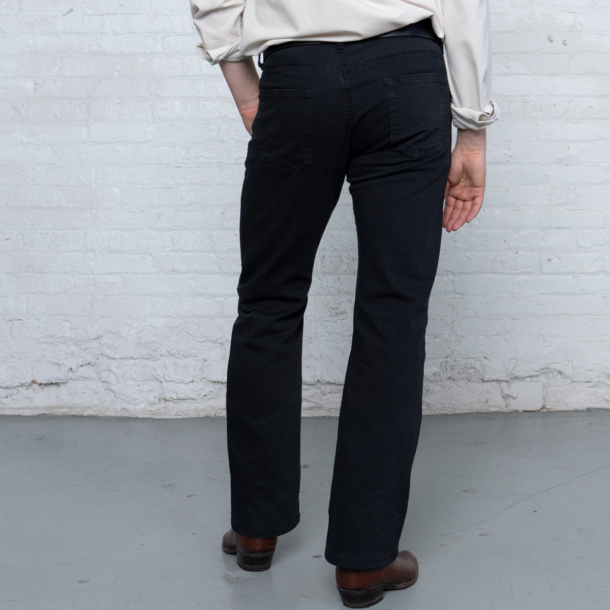 Back view of black boot cut jeans with five-pocket styling