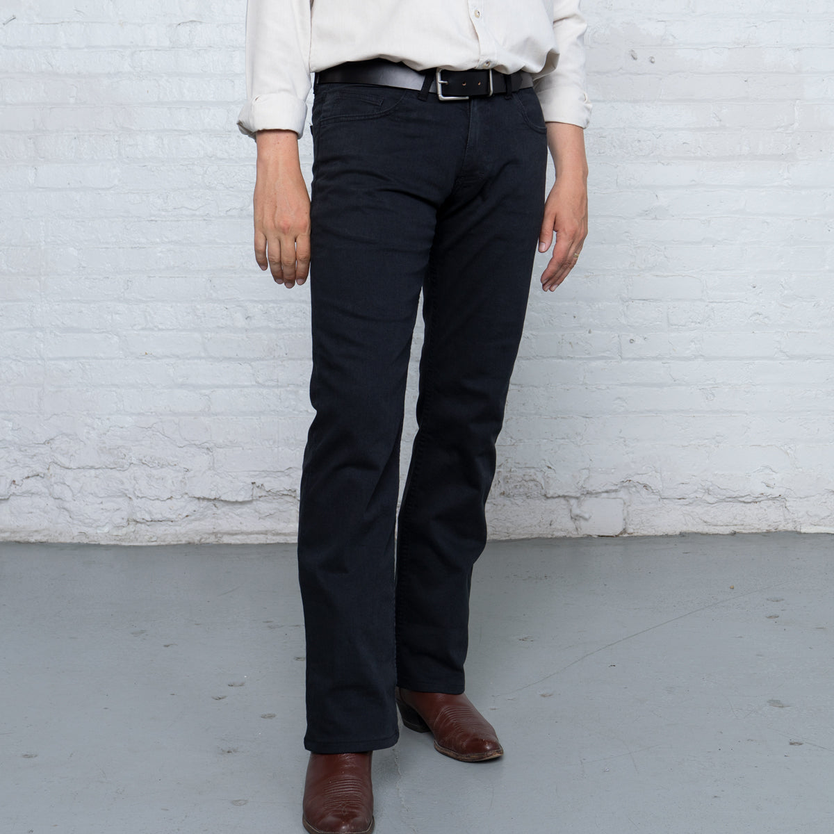 Black boot cut jeans shown front view, laid flat
