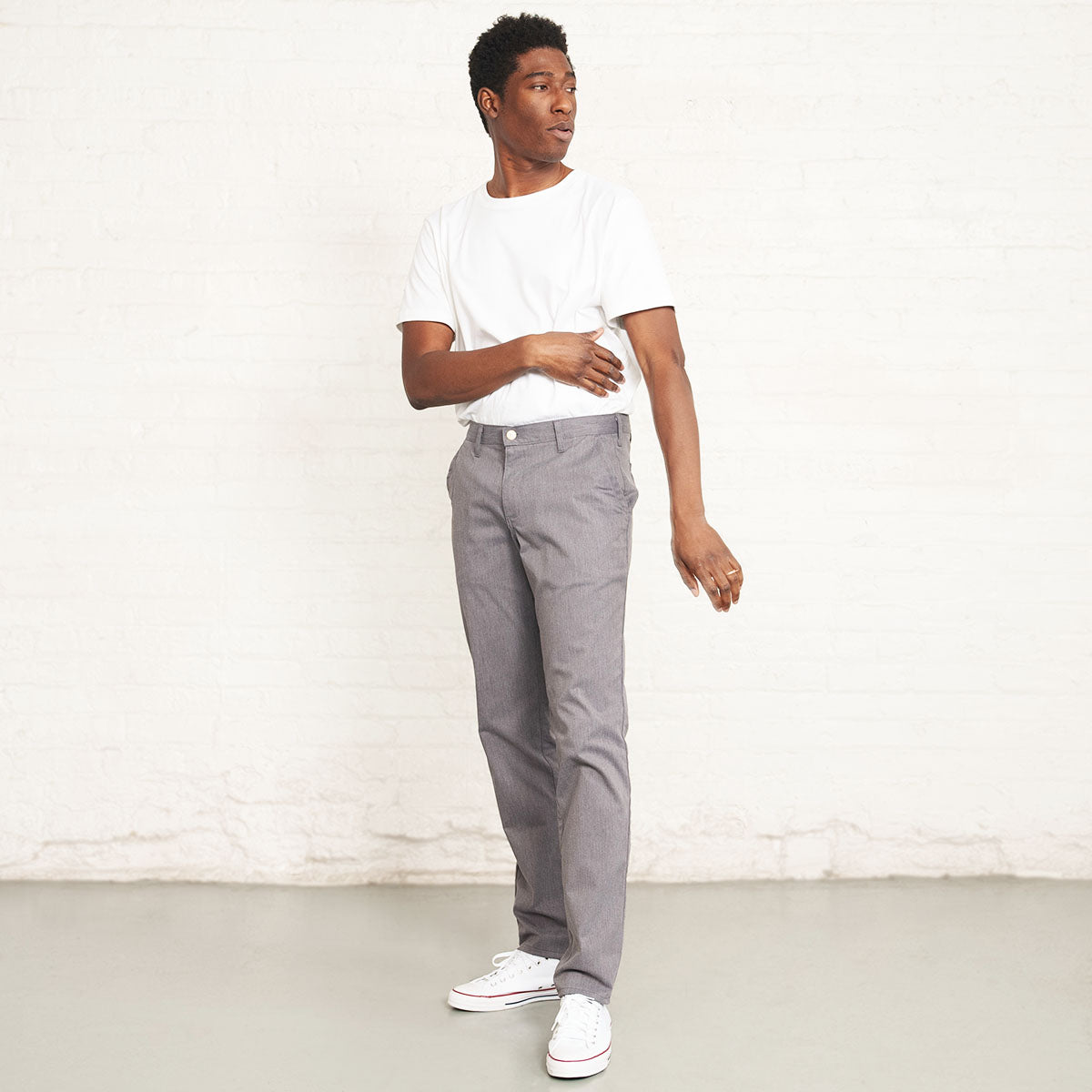 Detail of the button closure welt pocket on the back of the grey chino