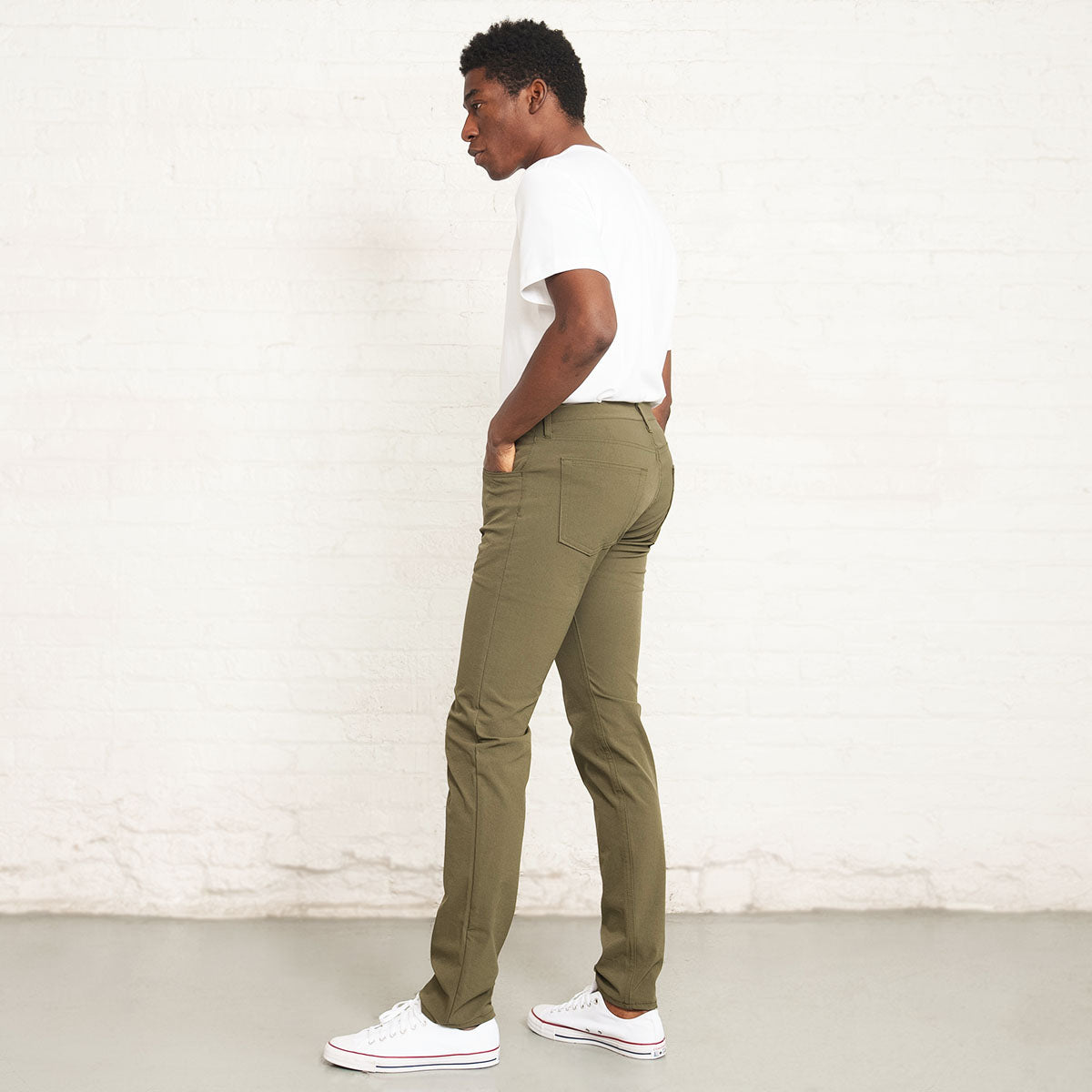 Detail of front pocket and stitching on olive technical jeans