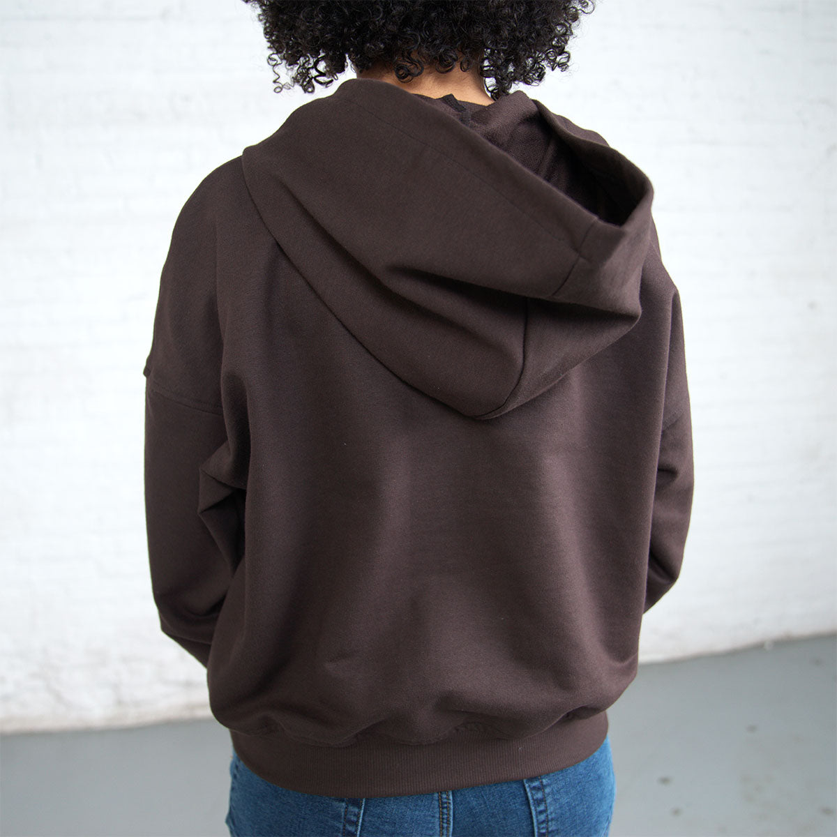 Model wearing the cropped hooded sweatshirt with the hood up.