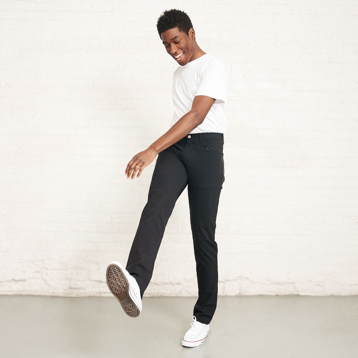 Back view of black technical pants with five-pocket styling