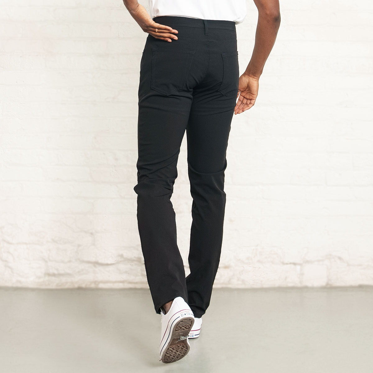 Man wearing black technical pants, back view