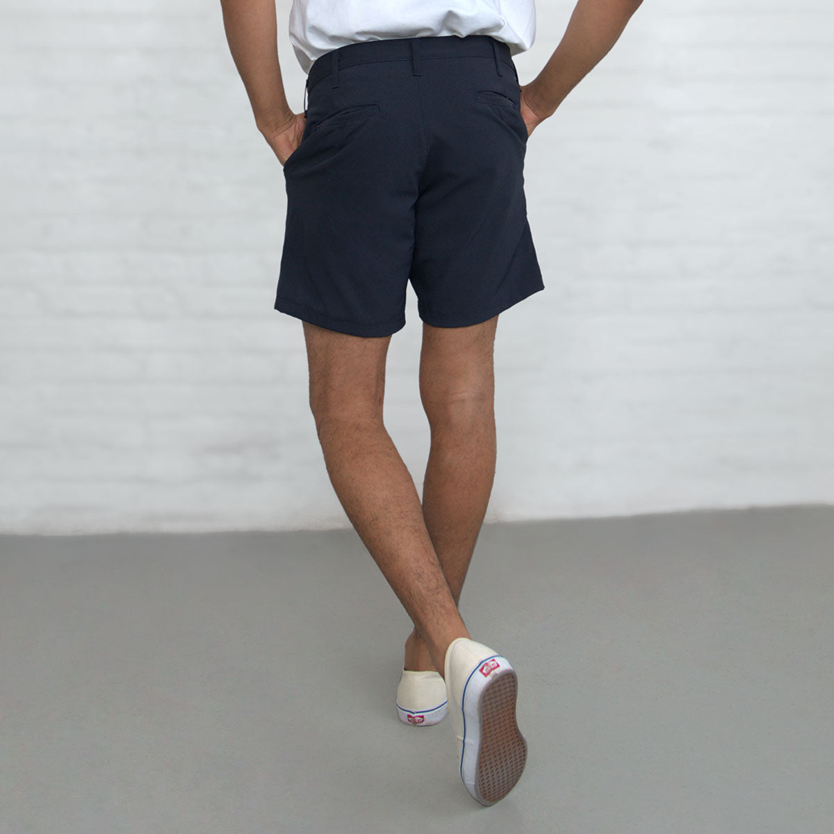 Man wearing the navy technical shorts, front view, full length.