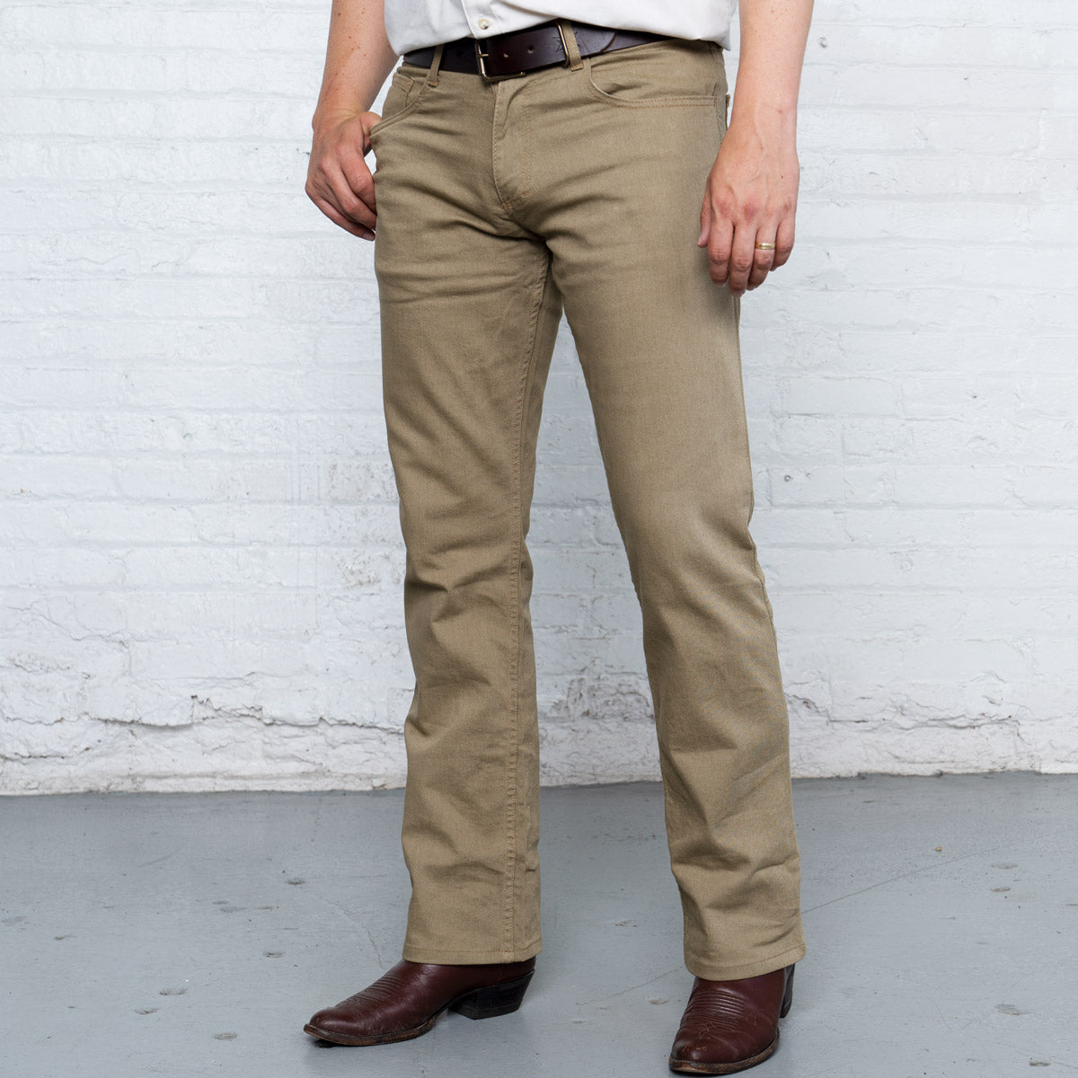 Khaki boot cut stretch jeans shown flat from the front with five-pocket styling and gold leaf button.