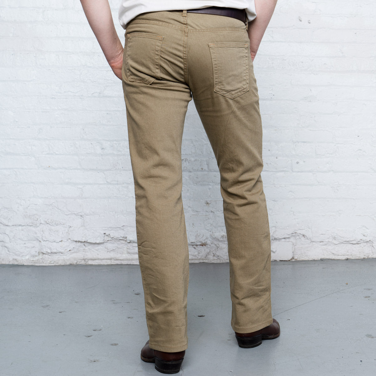 Back view of khaki boot cut jeans showing rear pockets and Horween leather patch at the waistband.