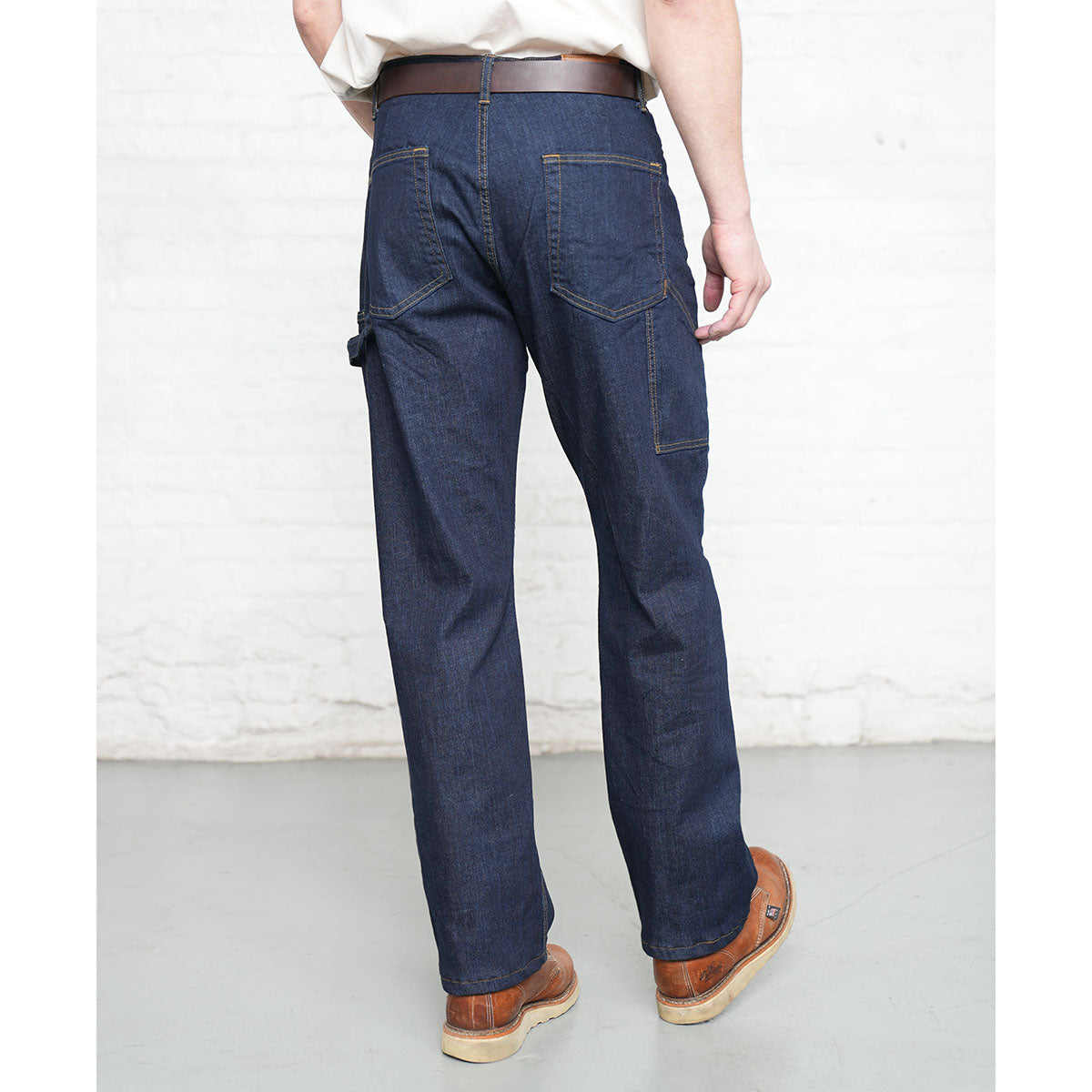 Man wearing dark wash carpenter jeans, side view showing utility pocket