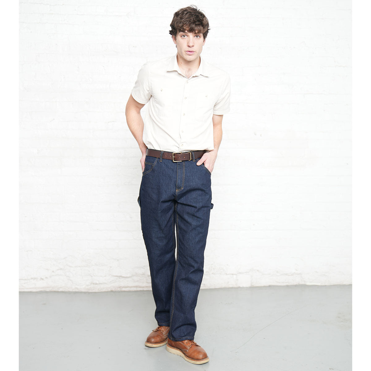Man wearing dark wash carpenter jeans, full length front view