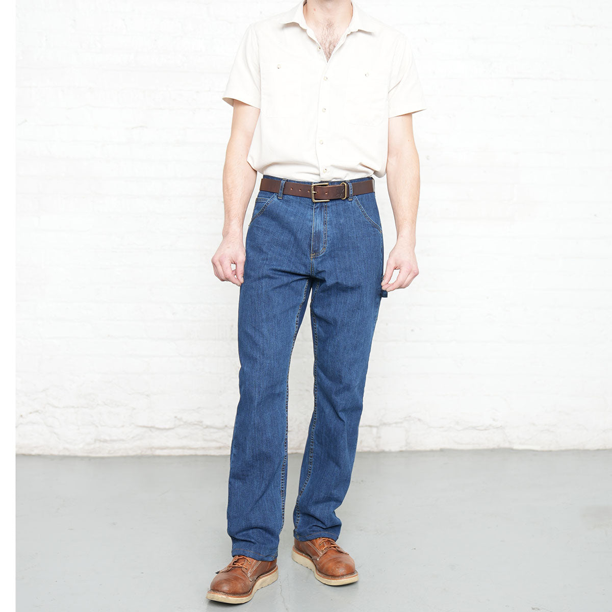 Back view of medium wash carpenter jeans showing large back pockets and darts